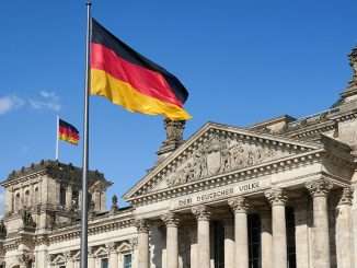 German flag over Deutscher Reichstag (Norbert Braun/Unsplash)